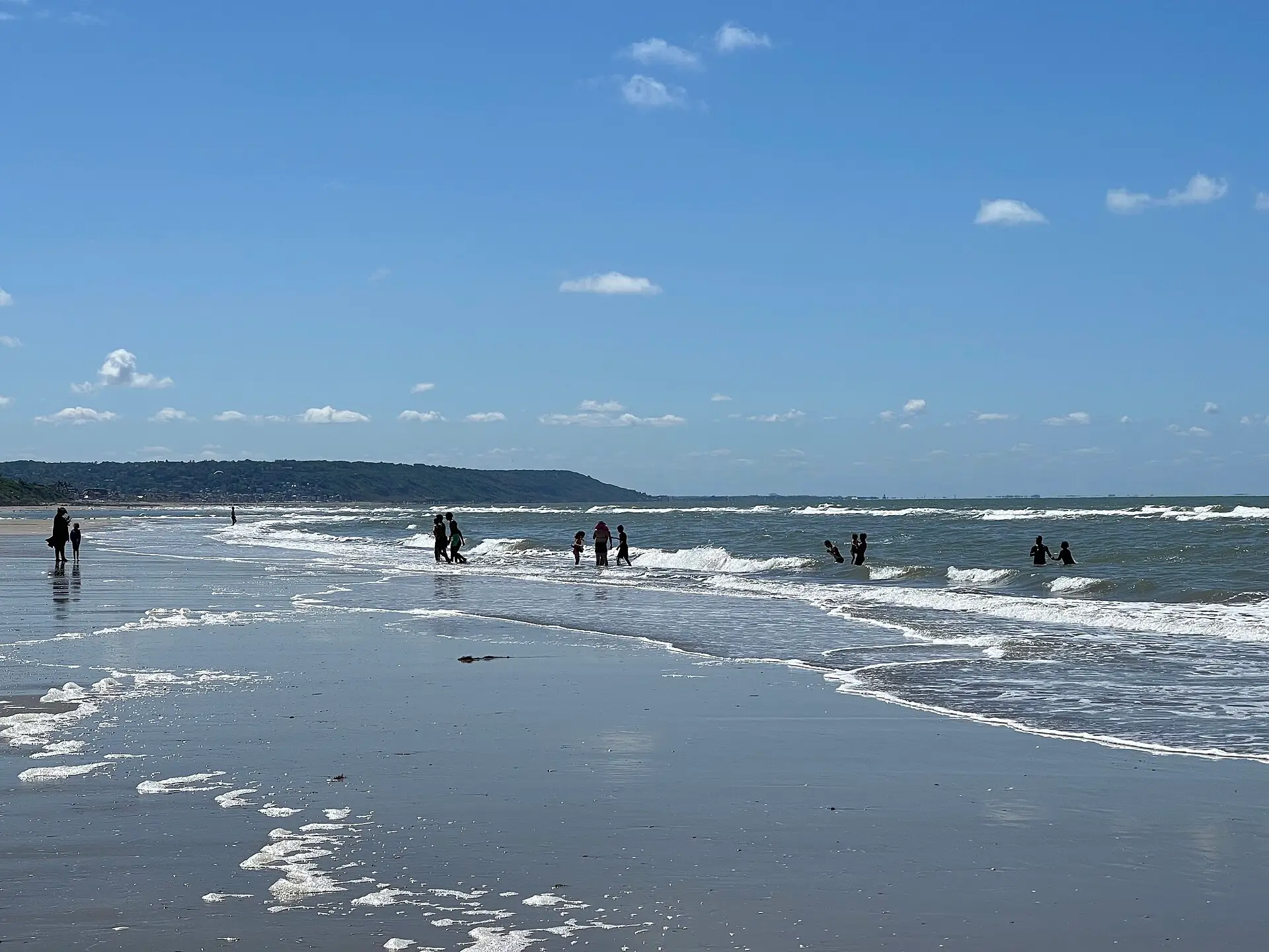 La plage de Deauville en juillet, des baigneurs dans les vagues